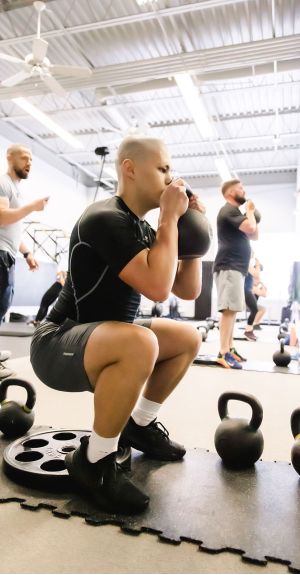 UPLIFT fitness class member performing a kettlebell squat