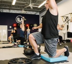 UPLIFT fitness class members performing overhead press