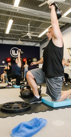 UPLIFT fitness class members performing overhead press