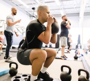 UPLIFT fitness class member performing a kettlebell squat