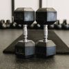 Two Dumbells in front of a fitness mat